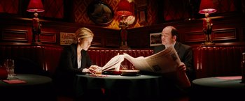 Movie still from “Thank You for Smoking” (2005), directed by Jason Reitman – A man and a woman sitting at a table reading newspapers; Medium shot, Low angle