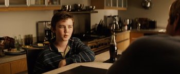 Movie still from “Thank You for Smoking” (2005), directed by Jason Reitman – A young man sitting at a counter with a bottle of soda; Close Up shot, Over the shoulder angle
