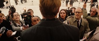 Movie still from “Thank You for Smoking” (2005), directed by Jason Reitman – A group of people are gathered around a man; Medium shot, Over the shoulder angle