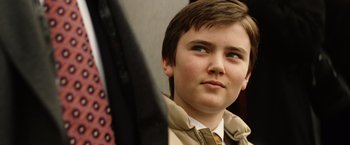 Movie still from “Thank You for Smoking” (2005), directed by Jason Reitman – A young boy in a jacket and tie looking up at the sky; Close Up shot, Low angle