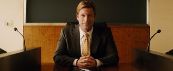 Movie still from “Thank You for Smoking” (2005), directed by Jason Reitman – A man sitting at a table wearing a suit and tie; Medium shot, Over the shoulder angle