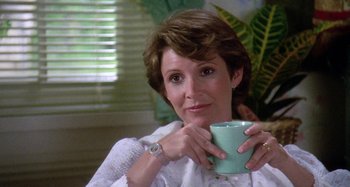 Movie still from “The 'Burbs” (1989), directed by Joe Dante – A person holding a coffee cup; Close Up shot, Over the shoulder angle