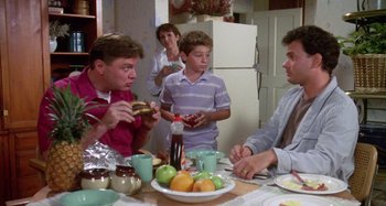Movie still from “The 'Burbs” (1989), directed by Joe Dante – A group of people sitting around a table eating food; Medium shot, High angle