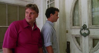 Movie still from “The 'Burbs” (1989), directed by Joe Dante – Two men standing next to each other near a wall; Medium shot, Low angle