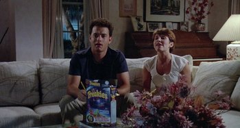 Movie still from “The 'Burbs” (1989), directed by Joe Dante – A man and a woman sitting on a couch; Medium shot, High angle
