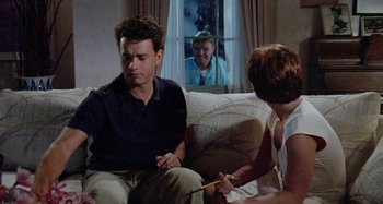 Movie still from “The 'Burbs” (1989), directed by Joe Dante – A man and a woman sitting on a couch; Medium shot, Over the shoulder angle