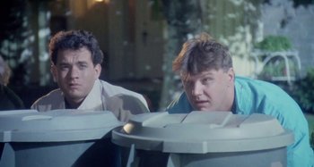Movie still from “The 'Burbs” (1989), directed by Joe Dante – A couple of men sitting next to each other in front of trash cans; Close Up shot, Low angle