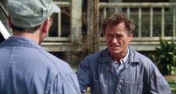 Movie still from “The 'Burbs” (1989), directed by Joe Dante – A man standing next to another man in a yard; Close Up shot, Over the shoulder angle