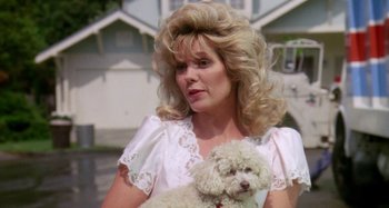 Movie still from “The 'Burbs” (1989), directed by Joe Dante – A woman holding a white dog while wearing a white dress; Close Up shot, Low angle