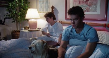 Movie still from “The 'Burbs” (1989), directed by Joe Dante – Two young men sitting on a bed with a dog; Medium shot, Over the shoulder angle