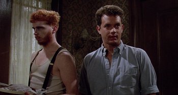 Movie still from “The 'Burbs” (1989), directed by Joe Dante – Two men standing next to each other in front of a wall; Medium shot, Low angle