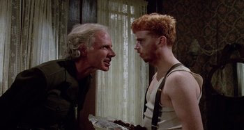 Movie still from “The 'Burbs” (1989), directed by Joe Dante – A man and a boy are talking to each other; Medium shot, Over the shoulder angle