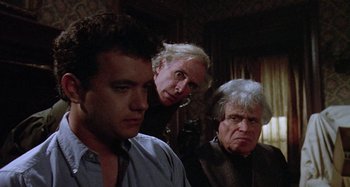 Movie still from “The 'Burbs” (1989), directed by Joe Dante – A group of men standing next to each other in a room; Medium shot, Over the shoulder angle