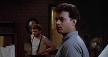 Movie still from “The 'Burbs” (1989), directed by Joe Dante – A man standing next to another man in front of a mirror; Medium shot, Low angle