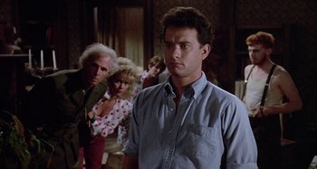 Movie still from “The 'Burbs” (1989), directed by Joe Dante – A man standing in front of a group of people; Medium shot, Low angle