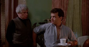 Movie still from “The 'Burbs” (1989), directed by Joe Dante – A man and a woman standing next to each other in front of a wall; Medium shot, Over the shoulder angle