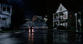 Movie still from “The 'Burbs” (1989), directed by Joe Dante – A car driving down a street at night; Wide shot, Low angle
