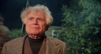 Movie still from “The 'Burbs” (1989), directed by Joe Dante – An older man in a brown jacket looks at the camera; Close Up shot, Low angle