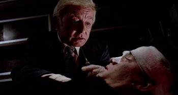 Movie still from “The 'Burbs” (1989), directed by Joe Dante – An older man in a suit and tie looking at another man in a suit and tie; Close Up shot, High angle