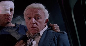 Movie still from “The 'Burbs” (1989), directed by Joe Dante – An older man is putting on a tie; Close Up shot, Over the shoulder angle