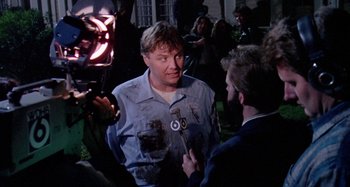 Movie still from “The 'Burbs” (1989), directed by Joe Dante – A man is being interviewed by a camera man; Medium shot, Over the shoulder angle