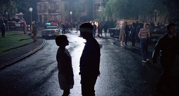 Movie still from “The 'Burbs” (1989), directed by Joe Dante – Two people standing on the side of the street; Wide shot, Over the shoulder angle