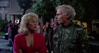 Movie still from “The 'Burbs” (1989), directed by Joe Dante – A man and a woman standing next to each other on the street; Medium shot, Over the shoulder angle
