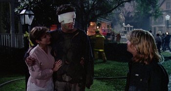 Movie still from “The 'Burbs” (1989), directed by Joe Dante – A man with a blindfold on and two women standing next to him; Medium shot, Over the shoulder angle