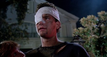 Movie still from “The 'Burbs” (1989), directed by Joe Dante – A man with bandages on his head and a bandage on his face; Close Up shot, Low angle