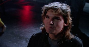 Movie still from “The 'Burbs” (1989), directed by Joe Dante – A man with long blonde hair wearing a black jacket; Close Up shot, Low angle