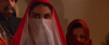 Movie still from “The 13th Warrior” (1999), directed by Michael Crichton – A woman wearing a red and white veil with another woman behind her; Close Up shot, Over the shoulder angle