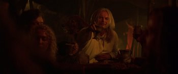 Movie still from “The 13th Warrior” (1999), directed by Michael Crichton – A man with long blonde hair is holding a cup; Close Up shot, Over the shoulder angle