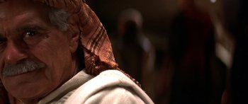 Movie still from “The 13th Warrior” (1999), directed by Michael Crichton – A man wearing a brown and white tie; Close Up shot, Over the shoulder angle