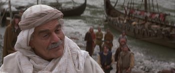 Movie still from “The 13th Warrior” (1999), directed by Michael Crichton – A group of people standing in the water near a body of water; Close Up shot, Over the shoulder angle