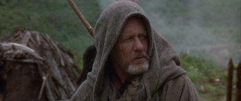 Movie still from “The 13th Warrior” (1999), directed by Michael Crichton – An old man with a long beard and a hood on; Close Up shot, Low angle