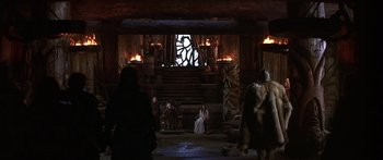 Movie still from “The 13th Warrior” (1999), directed by Michael Crichton – A group of people sitting in front of a fire pit; Wide shot, Low angle