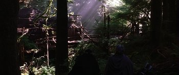 Movie still from “The 13th Warrior” (1999), directed by Michael Crichton – Two people are standing in the woods near a bridge; Wide shot, Low angle