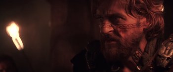 Movie still from “The 13th Warrior” (1999), directed by Michael Crichton – A man with long hair and a goatee is looking at the camera; Close Up shot, Over the shoulder angle