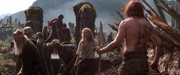 Movie still from “The 13th Warrior” (1999), directed by Michael Crichton – A group of people standing next to each other on top of a field; Medium shot, Low angle