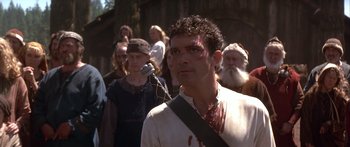 Movie still from “The 13th Warrior” (1999), directed by Michael Crichton – A group of people standing around a man with blood on his face; Close Up shot, Low angle