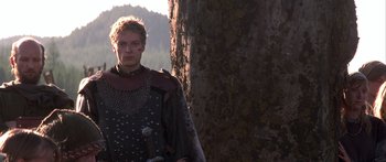 Movie still from “The 13th Warrior” (1999), directed by Michael Crichton – A man dressed as a knight standing next to a tree; Medium shot, Low angle