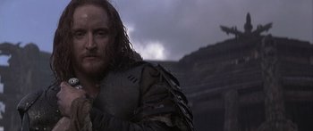 Movie still from “The 13th Warrior” (1999), directed by Michael Crichton – A person with a beard wearing armor; Close Up shot, Over the shoulder angle