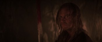 Movie still from “The 13th Warrior” (1999), directed by Michael Crichton – A man with long hair is holding a sword; Close Up shot, Over the shoulder angle