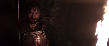 Movie still from “The 13th Warrior” (1999), directed by Michael Crichton – A man with a beard wearing a leather vest; Close Up shot, Low angle