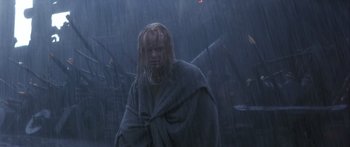 Movie still from “The 13th Warrior” (1999), directed by Michael Crichton – A man in a hooded robe standing in the rain; Medium shot, Low angle