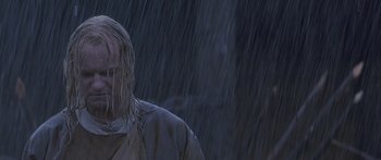 Movie still from “The 13th Warrior” (1999), directed by Michael Crichton – A man standing in the pouring rain with his head turned to the side; Close Up shot, Low angle
