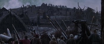 Movie still from “The 13th Warrior” (1999), directed by Michael Crichton – A group of people standing on top of a dirt hill; Extreme Wide shot, High angle