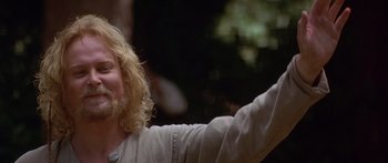 Movie still from “The 13th Warrior” (1999), directed by Michael Crichton – A man with long blonde curly hair waving; Close Up shot, Low angle