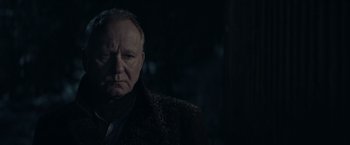 Movie still from “Out Stealing Horses” (2019), directed by Hans Petter Moland – An older man wearing a black coat and a black tie; Close Up shot, Over the shoulder angle