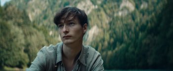 Movie still from “Out Stealing Horses” (2019), directed by Hans Petter Moland – A man with a beard is looking into the distance; Close Up shot, Low angle